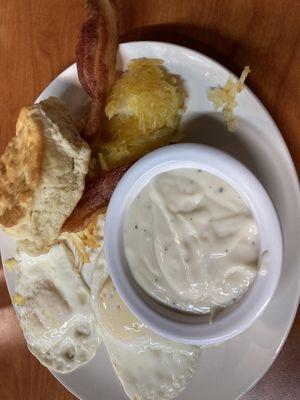 Two egg plater. Eggs over easy with bacon, hash browns and biscuits and gravy.