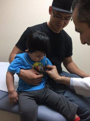 Dr. Arasheben showing my son how to use the stethoscope to listen to his own heart.