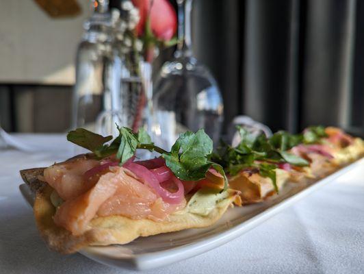 Spring 2022 Sourdough flatbread, Smoked Salmon, pickled onion, goat cheese, watercress + fennel pollen