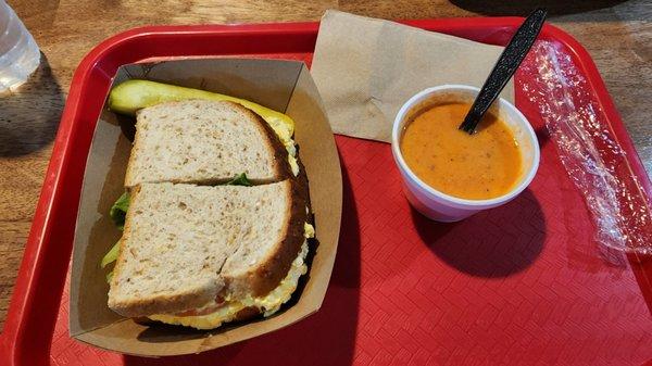 Egg salad sandwich and a cup of tomato basil soup.