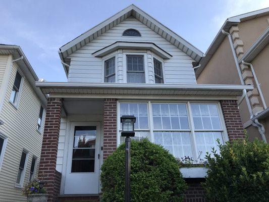 New seamless gutter in the front and new brown downspout along the side.