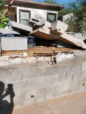 closeup of damage to retaining wall, rebar and column