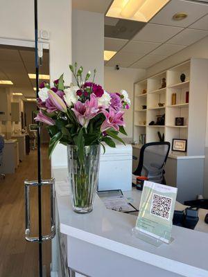 Beautiful front desk, with flowers from patients that LOVE New Smile Dental Center