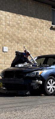 Applying urethane before setting new windshield in place.