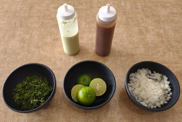 Salsa bottles, cilantro, limes, and diced white onions