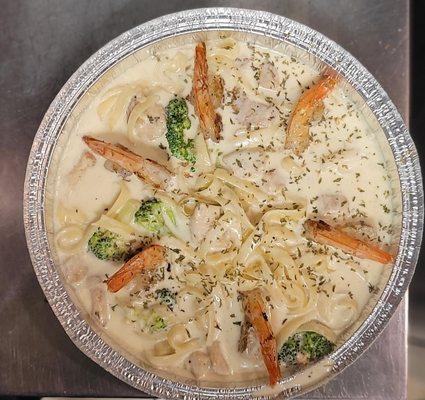 Fettuccini with homemade Alfredo sauce topped with Chicken, shrimp and broccoli