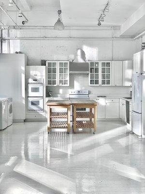 a fully-functional kitchen including four ovens, two stove tops, two sinks, microwave, refrigerator, freezer and ultra high ceilings