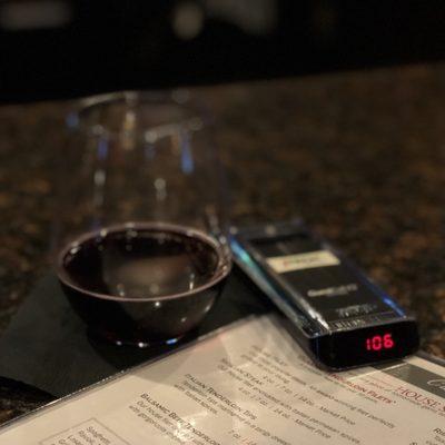 Sipping a red while waiting for a table!