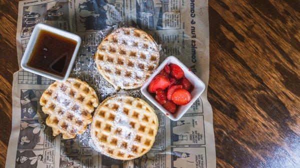 Waffles with syrup and strawberries.