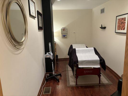 Treatment room with exam table and mirror on the wall