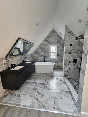 Beautiful attic bathroom with self standing tub, and an independent multi jet rain shower.