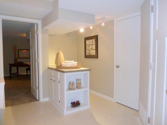 To avoid hitting a low ceiling in this basement laundry room, a folding counter with cabinets was added...