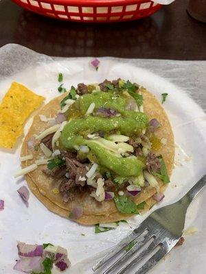 Steak taco with onion, cilantro and cheese