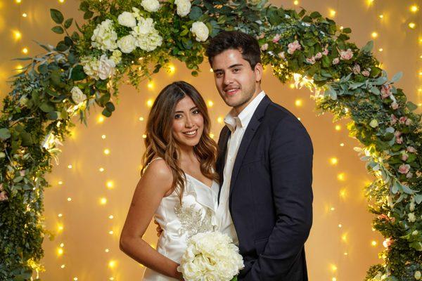 Couple taking photos by our floral arch