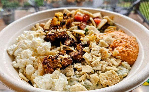 Cauliflower & Chickpea Grain Bowl. Tom., feta, eggpl., pepper, cucumber, pita chips. Pretty good, huge portion. Only spicy w/harissa sauce.