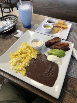 Un desayuno con Huevos, plátanos, queso, crema, frijoles y tortillas