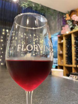 A lovely glass of "Glory wine," bar seating, wine stored in stock