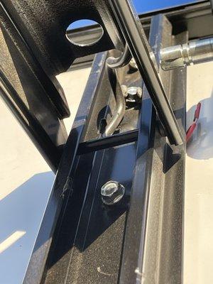 The 2 bolts holding the left or rear side of the awning arm hardware onto the trailer.