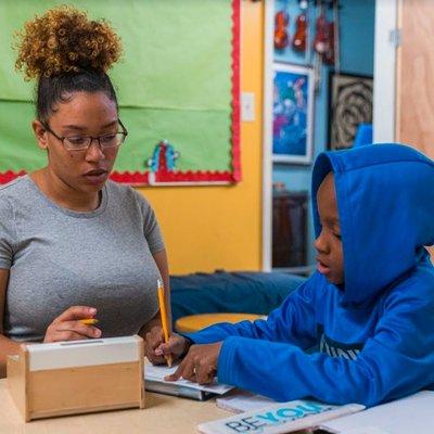 One of our academic liaisons helping a student with his homework after school.