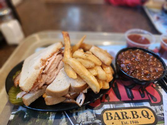 Turkey on bun on bread, crispy fries and a side of beans