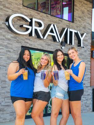 Group photo with drinks in front of Gravity sign