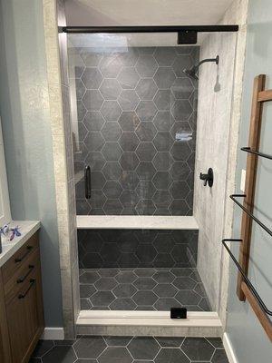 Single panel pivot mount shower door with matte black CR Laurence hinges.