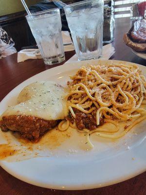 Grilled chicken parm with a side of spaghetti with added Parmesan cheese