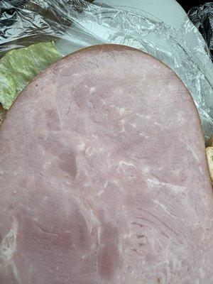 Very thick slice of ham on ham and cheese sandwich.