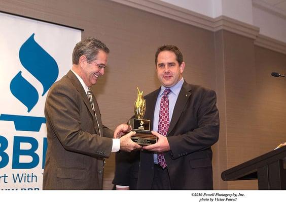 TV Anchor Ron Magers presenting John Baethke with the Torch Award for business ethics.