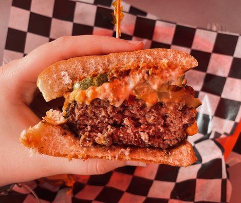 Burger with pimento cheese, chili, pickles, and mayo :) (there's a red tint to the photo because of the red tent we sat under)