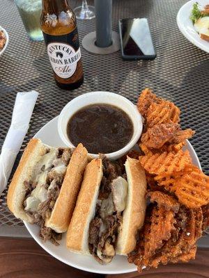 French dip sandwich with sweet potato waffle fries.