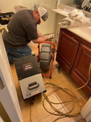 Charles, performing a sewer video inspection from a pulled toilet.