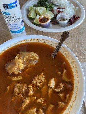 Menudo served with optional chile, oregano, onion, lemons, and cilantro.