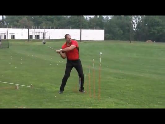 Greg the Golf Guy hitting off a 5' tall tee during one of his Corporate trick shot shows at the Golf Improvement Center in Medina, Ohio