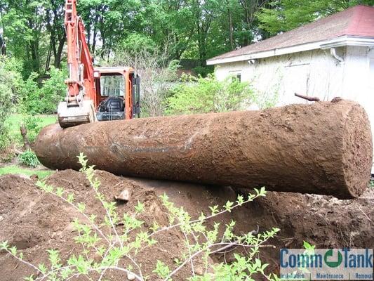 This picture is an underground oil tank being removed with an excavator.