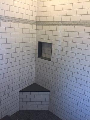 Custom built shower stall with granite bench and glass detail inlay.