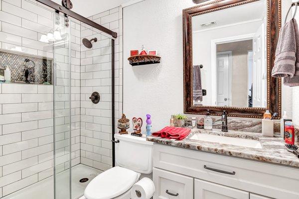 White subway tile, barn door sliding glass, all wood cabinets, vinyl plank flooring, new texture and paint.