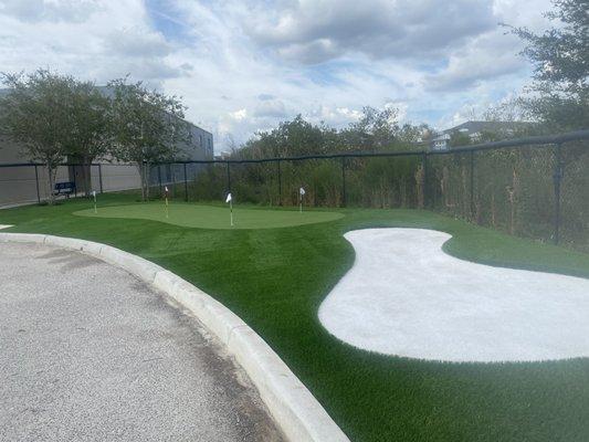 Beautiful putting green with a artificial sand trap