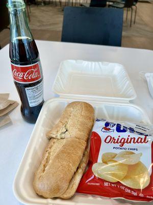 Cheesesteak sandwich with chips and soda