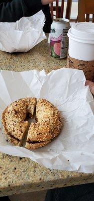 Everything bagel with a butter spread with a large coffee.