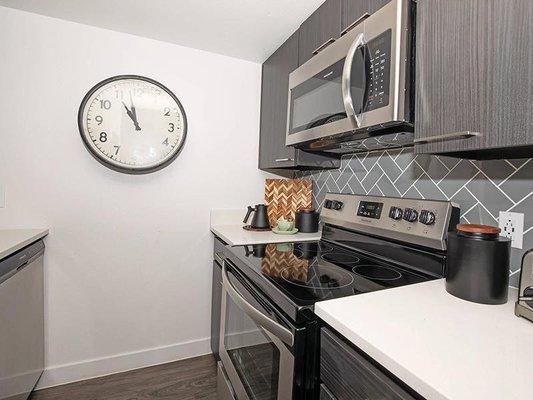 Enjoy quartz countertops with stainless sink and pull-down faucet, stainless steel appliances, breakfast bar, and more!