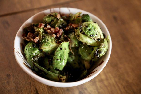 Fresh Crispy Brussel Sprouts topped with bacon bits and drizzled Balsamic Glaze