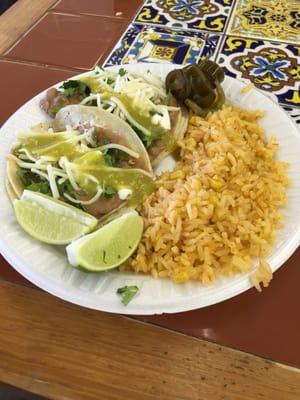 Two bean tacos with rice.