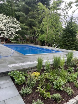 Seamless pool cover you can barely see rolled underneath the edge of the pool.