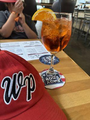 Baseball hat and Apérol spritz cocktail