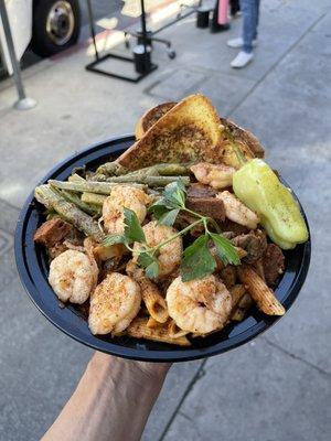 Jambalaya pasta served with asparagus and garlic bread