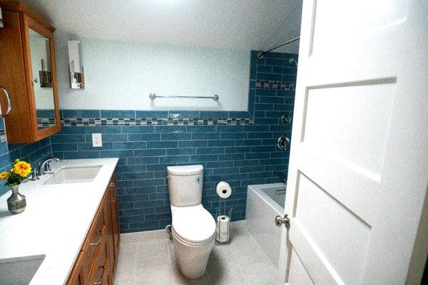 We squeezed in some linen storage behind the door.  Note the random stagger pattern for the tile.