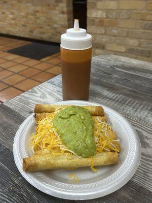 Rolled Tacos topped with cheese and guacamole. Clean and crunchy.