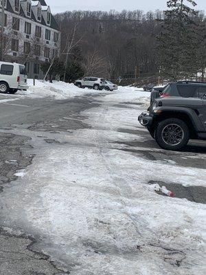 Unplowed parking lit. TWO plows amd the water bottle in parking lot is where I fell