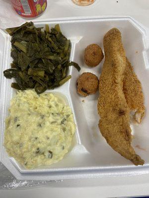 Fried catfish with hush puppies, greens, and potato salad.